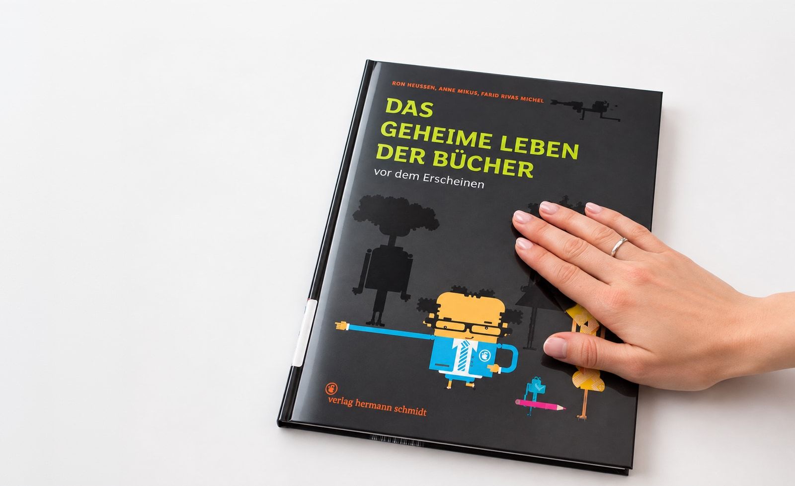 Hand resting on the illustrated book cover of “Das geheime Leben der Bücher”